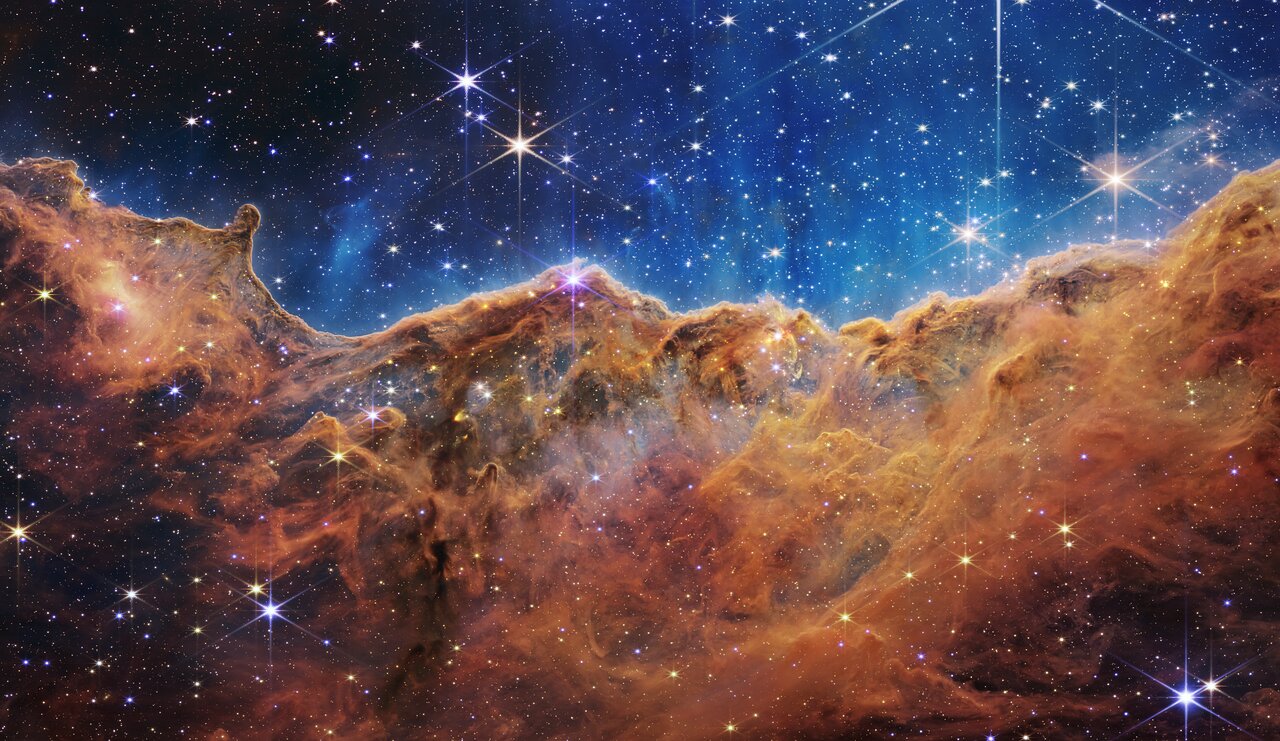 船底座星云中布满恒星的橙褐色气体悬崖