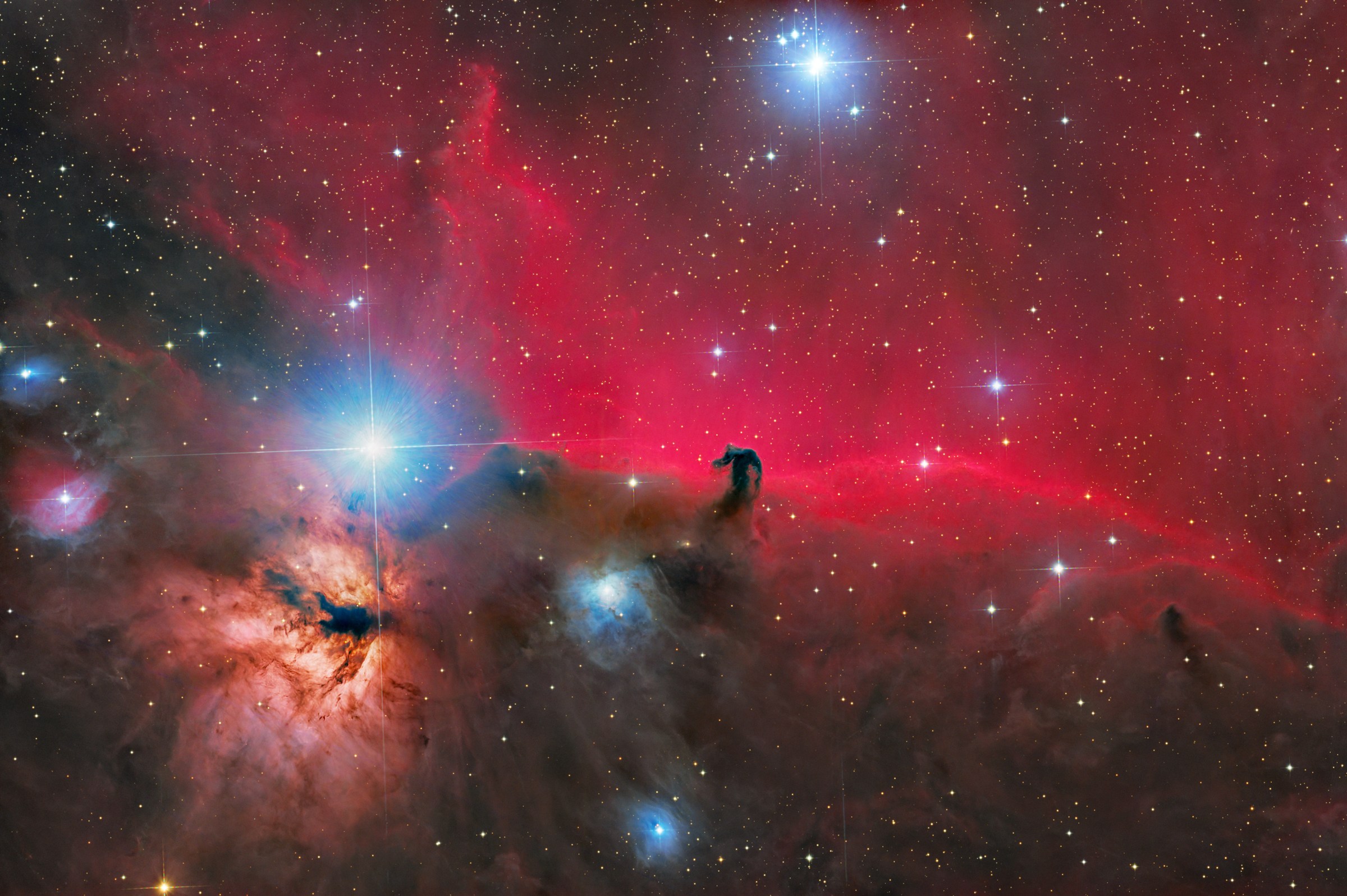 红色 IC 434 发射星云前的马头暗星云，周围可见火焰星云与明亮恒星参宿一